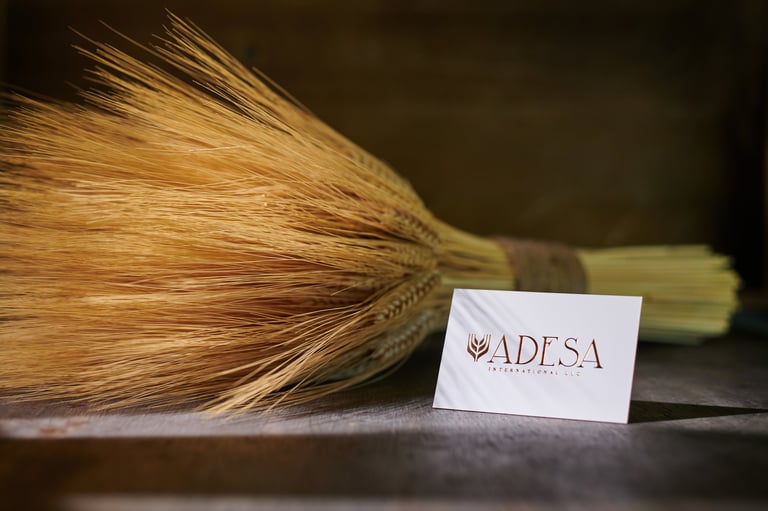 Bundle of dried wheat with ADESA label card on dark surface